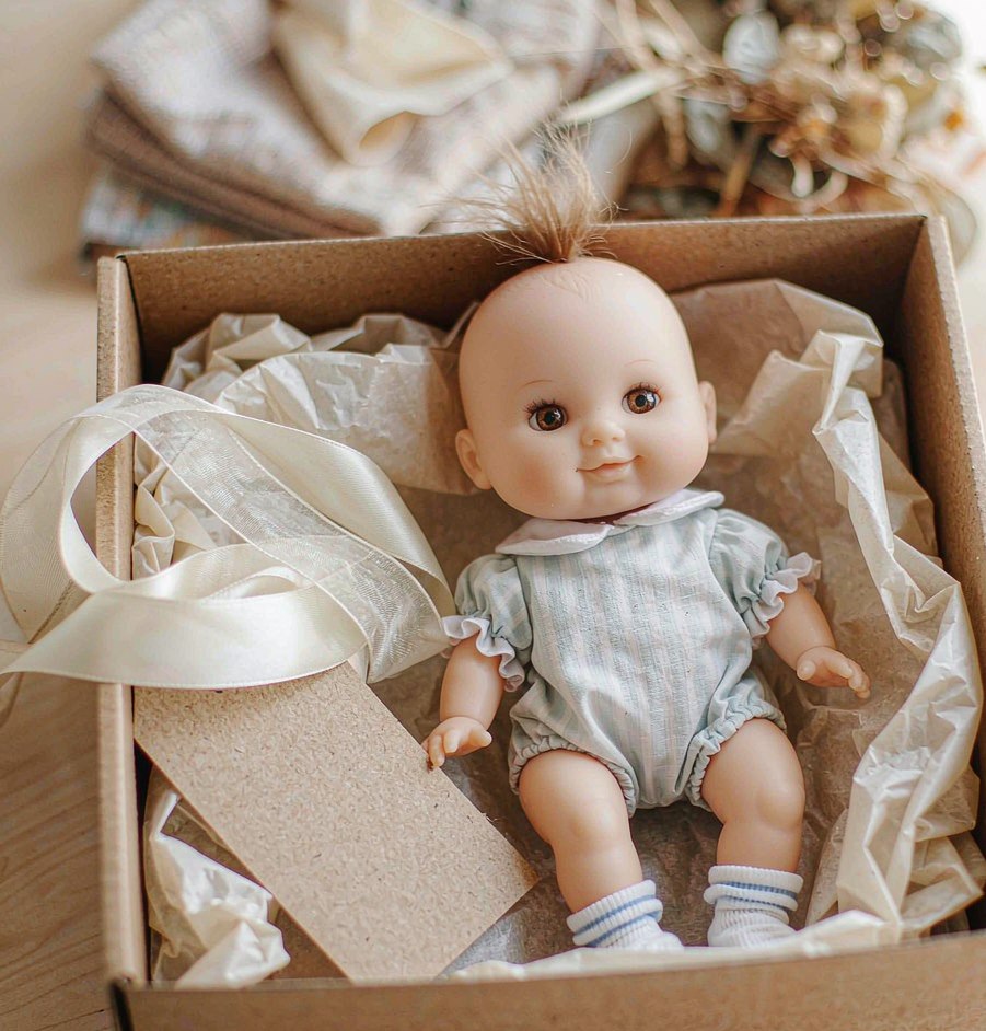 Soft baby doll packed in a gift box with ribbon and hang tag