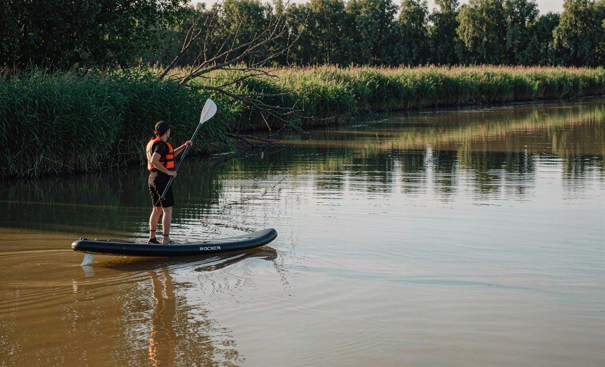 Paddling an inflatable paddleboard on a quiet river
